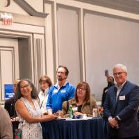 Shot of room as attendees give their attention to someone off-camera